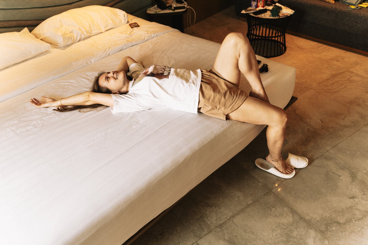 A woman lounges on a bed in a hotel room, capturing a moment of relaxation in Phuket, Thailand.